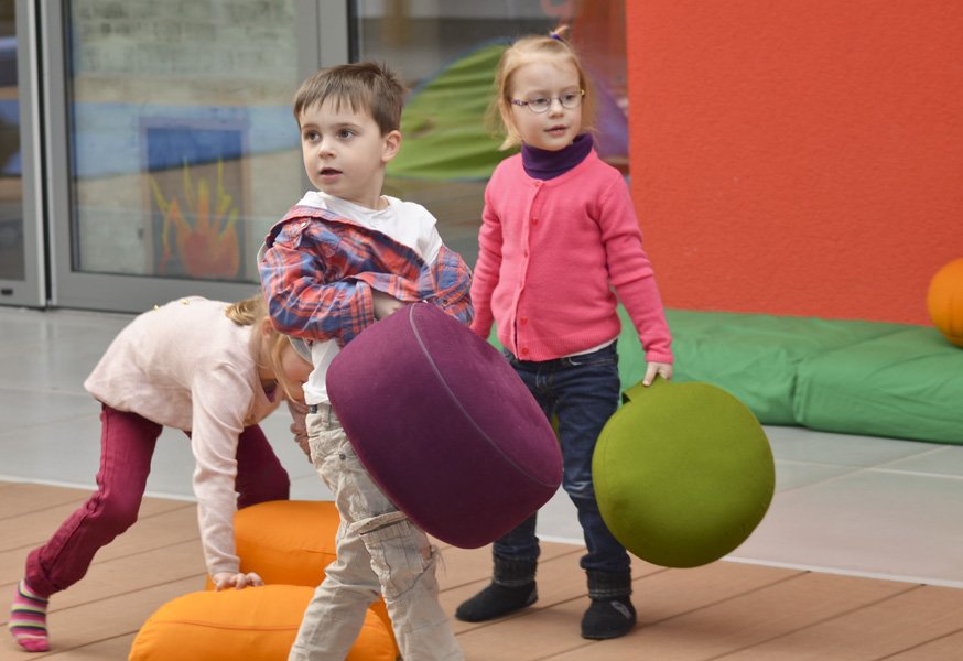 Kinder tragen Bodenkissen an Tragegriffen